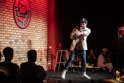 Comedian with audience interaction at Laughter Lounge comedian on stage pointing to audience member